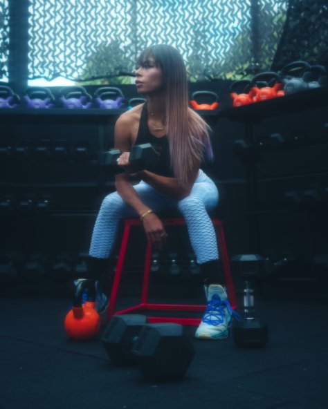 A woman at the gym sitting down training.